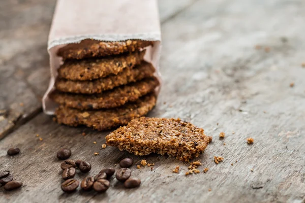 Galletas de café en una bolsa de papel y esparcidas en la mesa — Foto de Stock