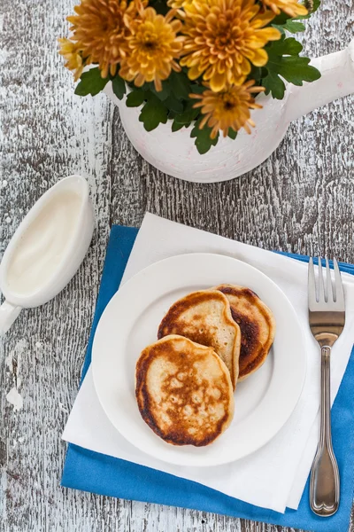 Crêpes au sirop, confiture et fleurs sur la table en bois — Photo