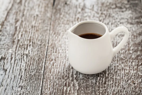 White gravy boat on a rustic wooden background — Stock Photo, Image