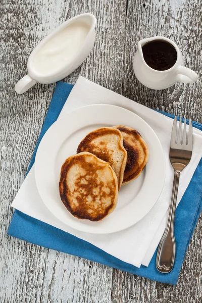 Pancakes with syrup, jam and flowers on the wooden table — Stock Photo, Image