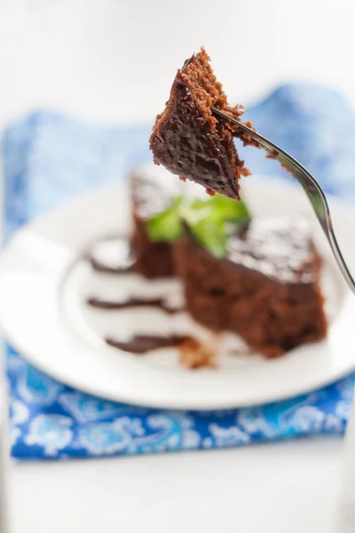 Pastel de chocolate en un plato de dulce de azúcar, y servilleta azul — Foto de Stock