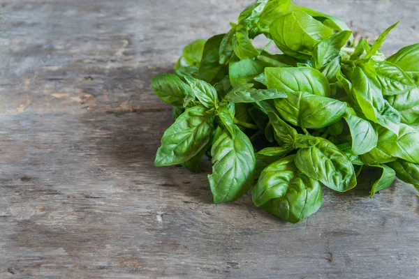 bunch of basil lie on a wooden table background