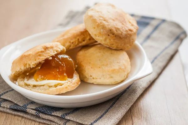 Scones with butter and jam on a napkin and Bank of jam — Stock Photo, Image