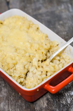 Seramik form arka plan ahşap masa üzerinde pişmiş peynirli makarna