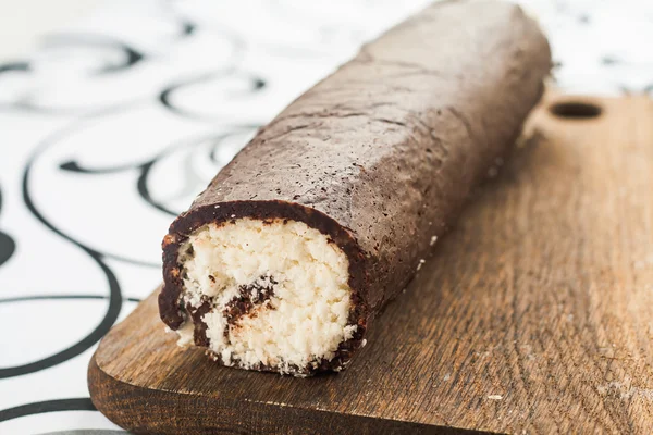 Rollo retorcido de coco y chocolate en una tabla de madera — Foto de Stock