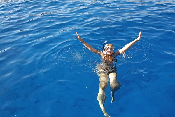 Молодая женщина в маске плавает в море — стоковое фото