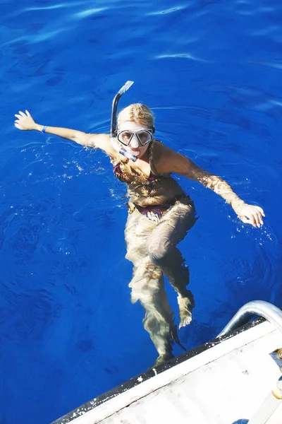 Jeune femme dans un masque flotte dans la mer — Photo