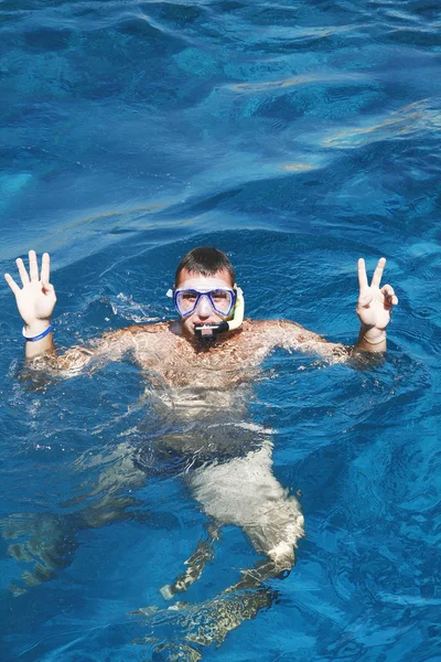 Jeune homme dans un masque flotte dans la mer — Photo
