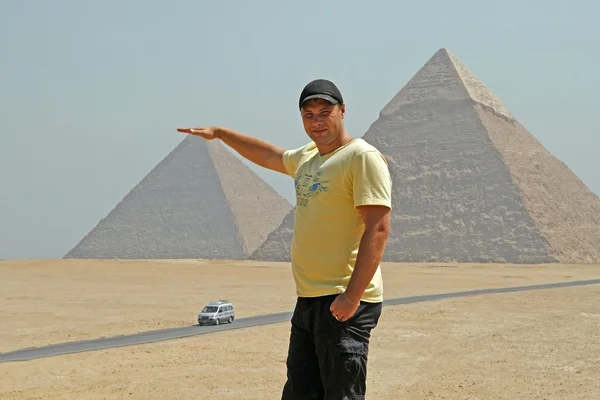 Man voor toeristen op een achtergrond van de piramides van Gizeh. Egypte. — Stockfoto