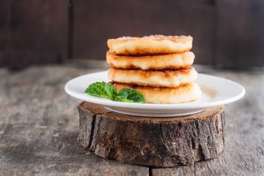 Beyaz bir tabak ve koyu ahşap backgrou cheesecakes yığını