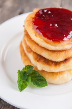 bir kara tahta üzerinde beyaz bir tabakta reçelli cheesecakes yığını 