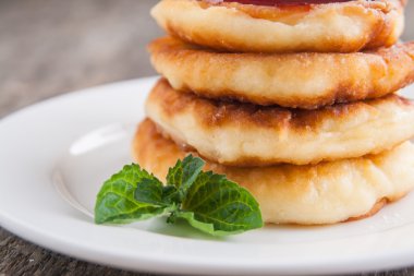 bir kara tahta üzerinde beyaz bir tabakta reçelli cheesecakes yığını 