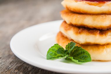 bir kara tahta üzerinde beyaz bir tabakta reçelli cheesecakes yığını 