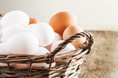 Ahşap arka plan üzerinde sepetinde tavuk yumurtası