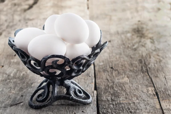 Huevos blancos de gallina crudos en un jarrón antiguo de hierro — Foto de Stock