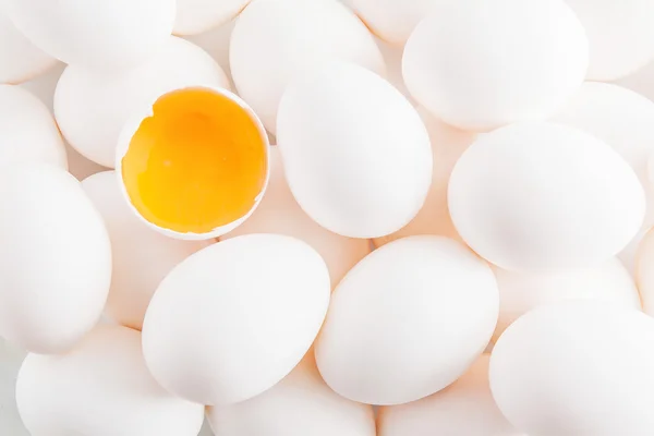 Fundo de ovos de galinha branca e gema de ovo na casca — Fotografia de Stock