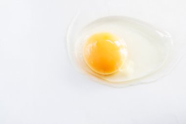 Beyaz yumurta kırık ve beyaz bir arka plan üzerinde sızdırılmış.