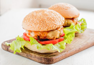 İki hamburger bir ahşap tahta üzerinde yatıyordu