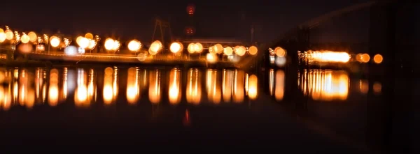 Luci della città di notte riflessa nel fiume che si estende nel — Foto Stock