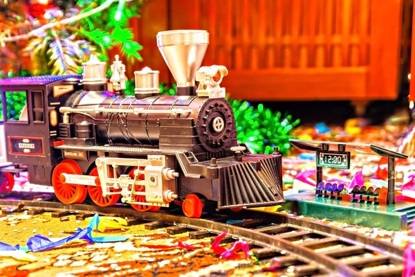 Ferrovia de brinquedo de Natal perto de uma árvore de Natal com luzes — Fotografia de Stock