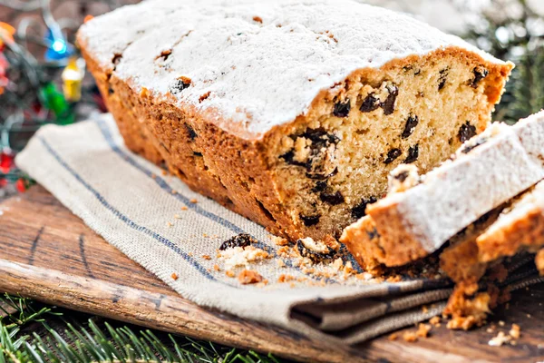 Cake with raisins sprinkled with icing on a wooden table with Ch — Stock Photo, Image