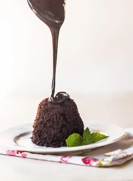 Para verter pastel de chocolate con jarabe de chocolate y hojas de menta en un — Foto de Stock
