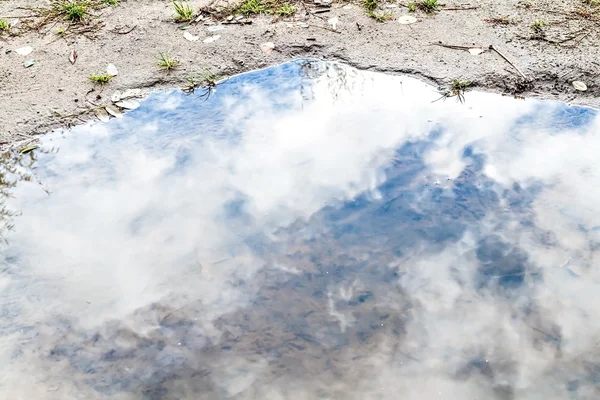 暴风雨的乌云的天空反射在水坑里 — 图库照片