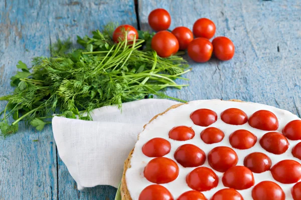 zucchini cake with tomato and parsley on a blue wooden