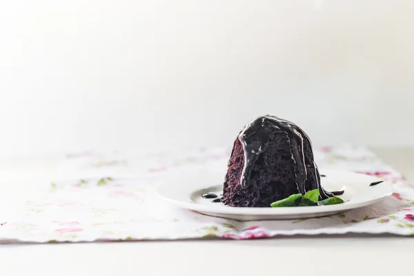 Pastel de chocolate con jarabe de chocolate con hojas de menta en un blanco — Foto de Stock