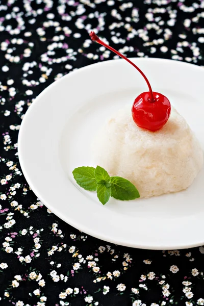 Dessert mousse bianca aria su un piatto decorato con una ciliegia e — Foto Stock