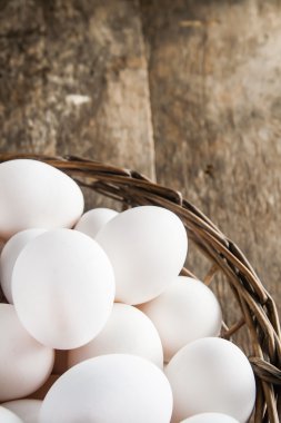 Ahşap arka plan üzerinde sepetinde tavuk yumurtası