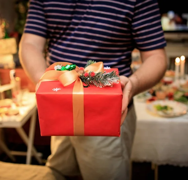 Young man holds out presents new year beautiful gift box — Stock Photo, Image