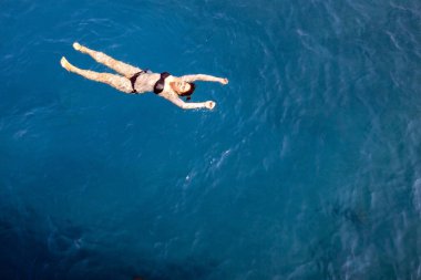 Siyah mayo giyen mutlu kadın Kızıl Deniz 'de, Mısır' da, Sharm el Sheikh 'te yüzüyor. Tatil ve macera. Mavi su. Denizde dinlenen tembel bir kızın en iyi görüntüsü. Boşluğu kopyala