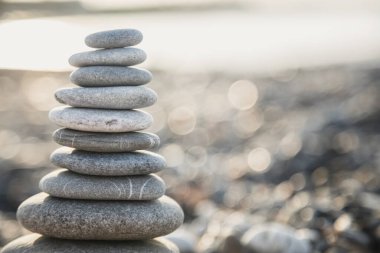 Güneş doğarken Türkiye sahilinde gri çakıl taşı piramidi. Zen konsepti, rahatlama. Sakinlik, denge