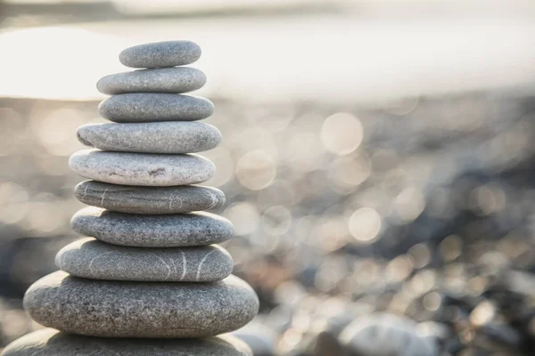 Pirámide de piedras grises en la playa de Turquía al amanecer. Concepto zen, relajación. calma, equilibrio Imagen De Stock