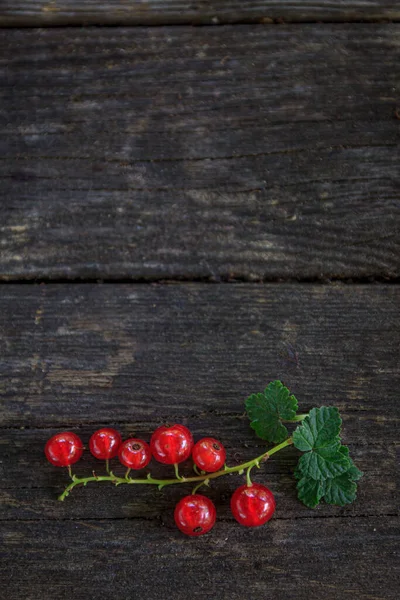Eski, koyu bir ahşap zemin üzerinde sulu taze kırmızı üzümler, üst manzara..