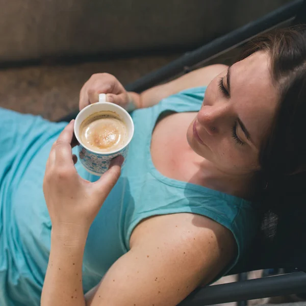 Jeune femme heureuse caucasienne buvant du café au soleil, vue de dessus — Photo