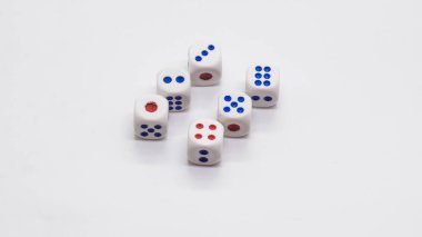 Beyaz kübik ağaç yığını. Beyaz zemin üzerinde mavi ve kırmızı sivri uçlu altı parça. Oyun, kumar, şans ve risk konsepti