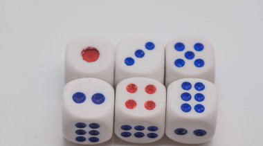 Beyaz arka planda mavi ve kırmızı sivri uçlu beyaz oyun kübikleri. Oyun, kumar, şans ve risk konsepti