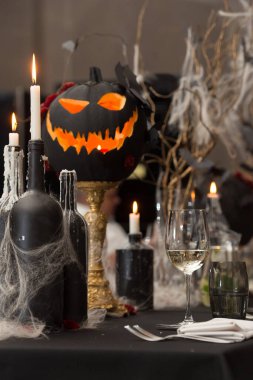 Cadılar Bayramı yemeği için masa hazır. Mum ve balkabağı ile servis edilen tatil masası. siyah masa örtüsü