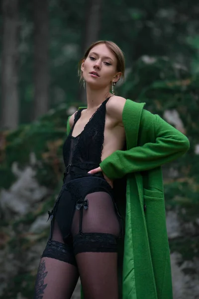 Divatos Fiatal Zöld Kabátban Fekete Harisnyában Egy Erdőben Pózol Egy — Stock Fotó