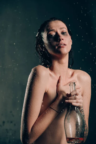 若いかわいいブルネットの女性は 水と花とお風呂で入れ墨 黒風呂で珍しい写真撮影中の裸のモデルワインを飲む — ストック写真