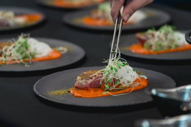 Gri seramik tabakta soğanlı ızgara ton balığı bifteği. Seçici odak, yakın plan.