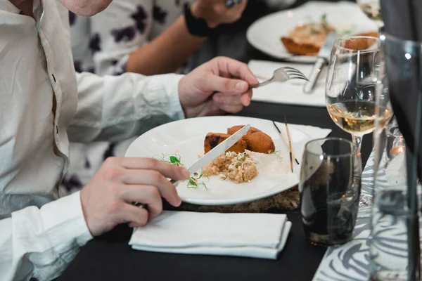 Pirinç ve mikro yeşil seramik tabakta gevrek ve sulu et yiyen bir adam.