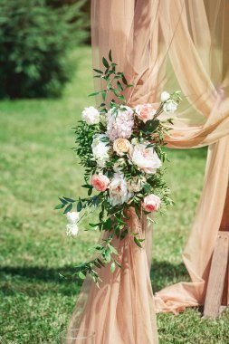 Bahçede çiçeklerle süslenmiş turuncu düğün kemeri. Yaz zamanı.