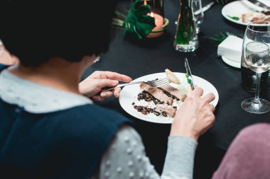 Bir restoranda Küba usulü sığır eti yiyen bir kadın pilav ve siyah fasulyeyle servis ediliyor. Masada servis edilen siyah masa örtüsü..