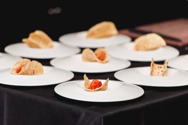 Bir kızın eli domatesi takoya koyar. Restorandaki şef aynı anda lahana salatası ve salsa soslu baharatlı karidesli taco yapacak.