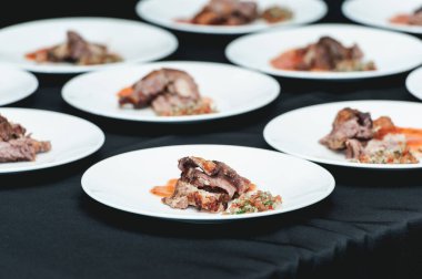 Beyaz tabakta ev yapımı pirzola servis ediliyor. Küçük bölüm