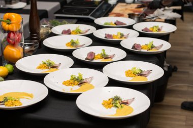 Orta pişmiş domuz bifteği. Tabağında da havuç püresi ve mısır var.