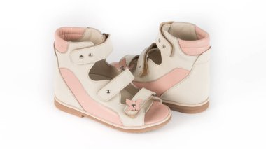 Beyaz arkaplanda bej renkli ortopedik sandaletler